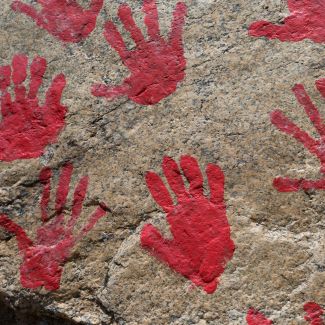 Red paint hand prints on a boulder