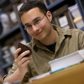 Undergraduate student considering a stone tool