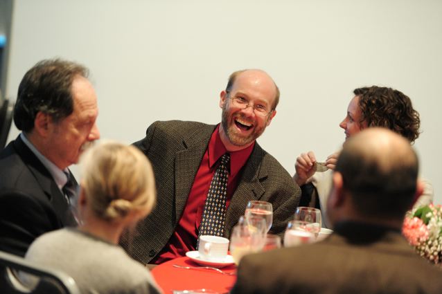 Dean Adams laughing with others at the reception