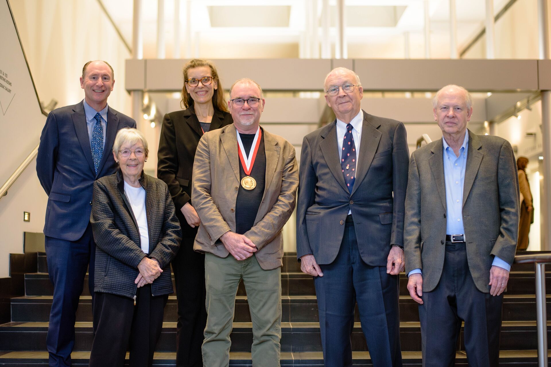 A group photograph of Dean David Wrobel, Janice Rohlf, Kathy Twiss, David Polly wearing his medal, Jim Rohlf, and Eric Delson