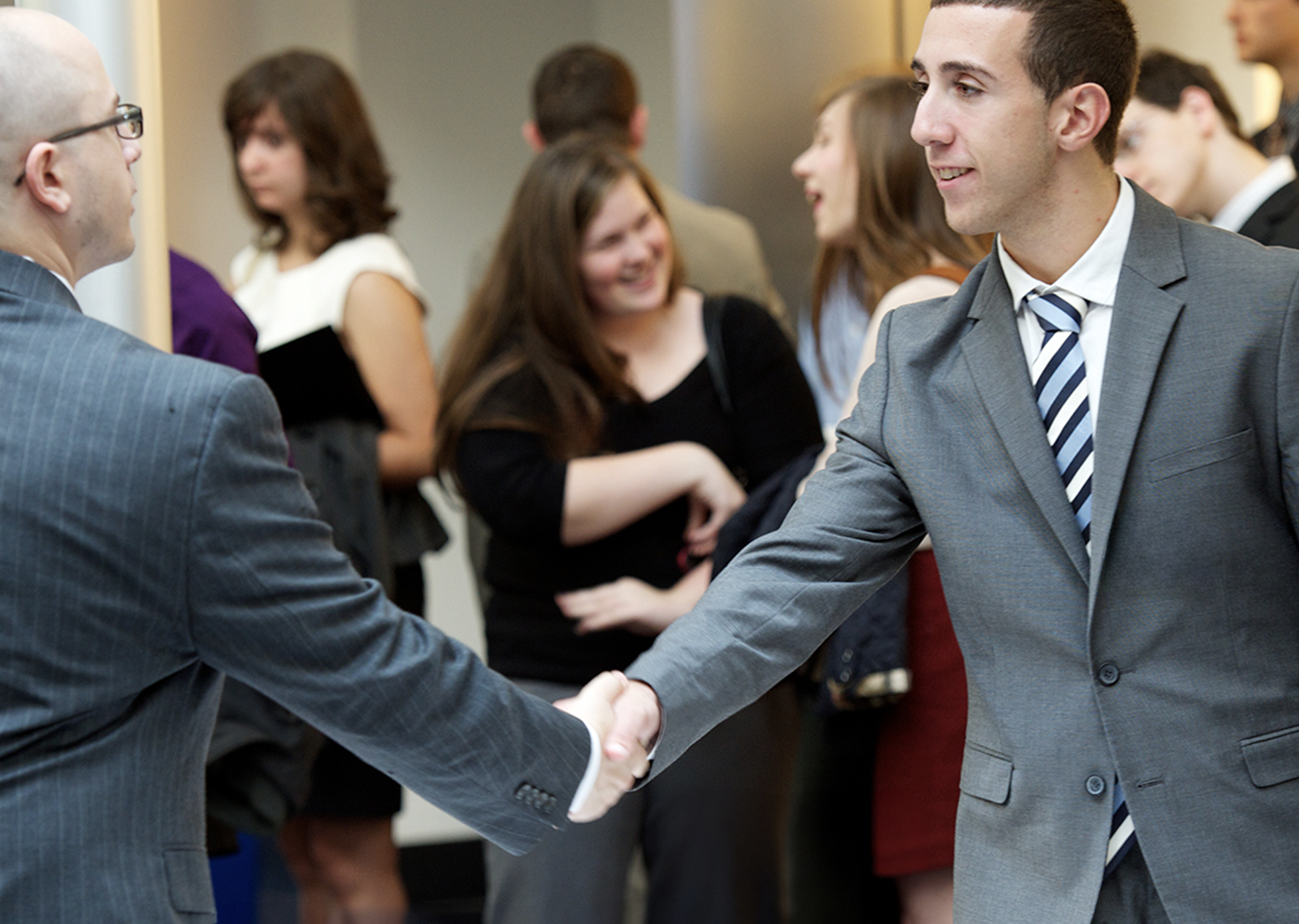 Student shaking hands with an employer at event
