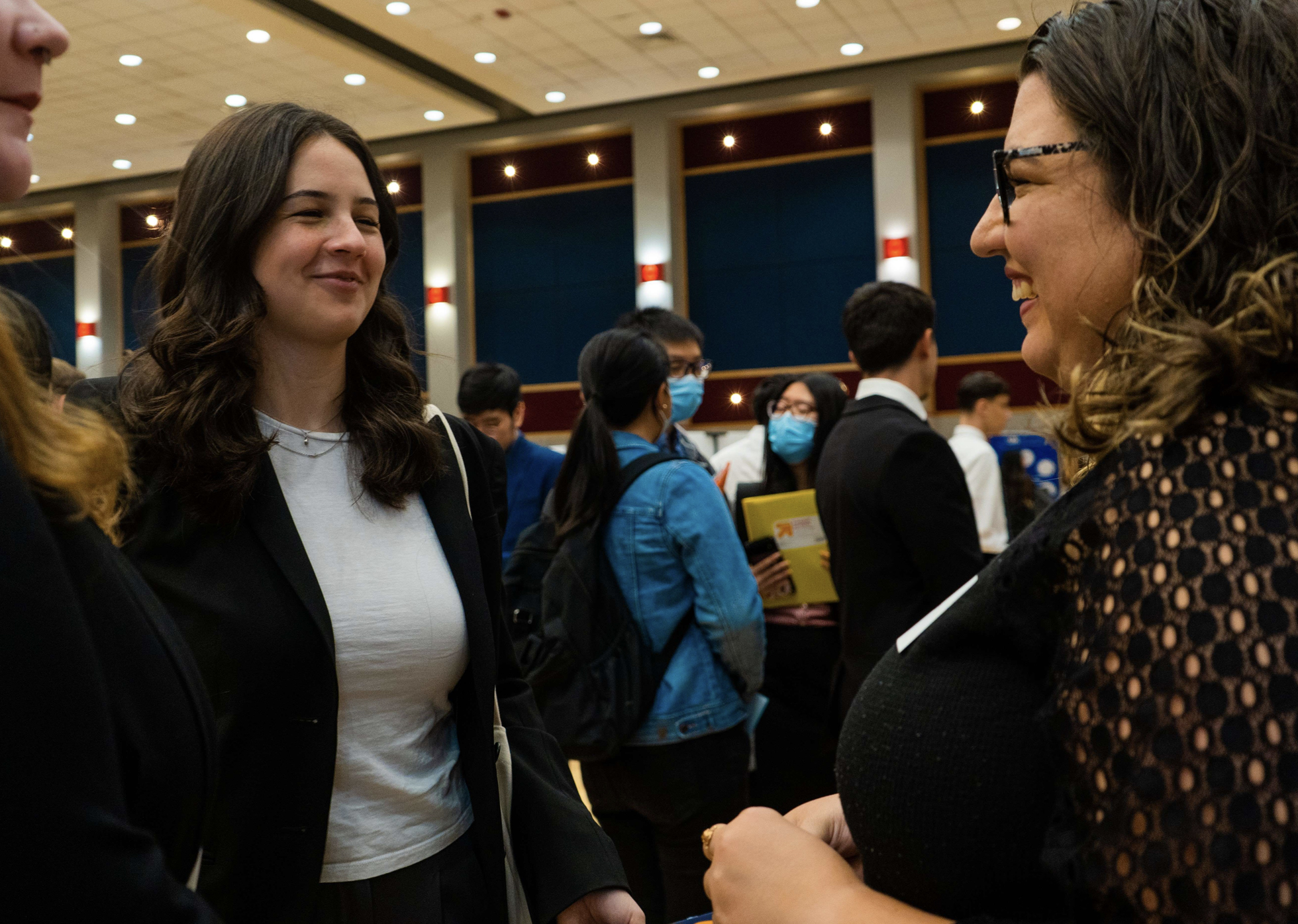 Two students talking to an employer at the job fair