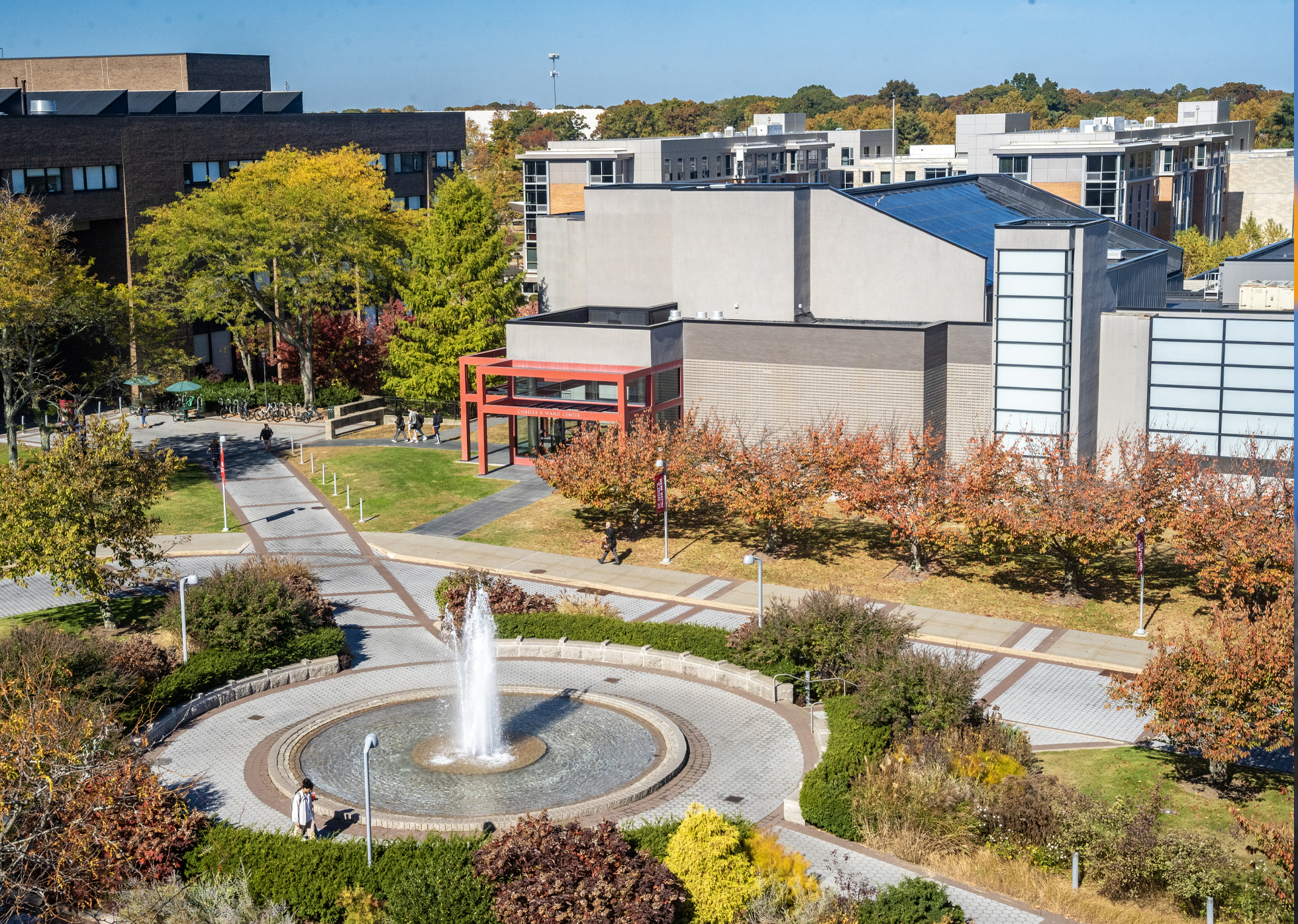 Aerial view of Wang Center at Stony Brook University with a circular fountain and autumn trees