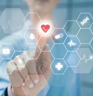 A hand reaches toward a glowing red heart icon in a digital health interface with honeycomb patterns, surrounded by various health-related symbols.