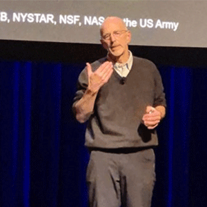 A man giving a lecture on stage.