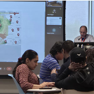 Classroom with students and a map presentation on a screen.