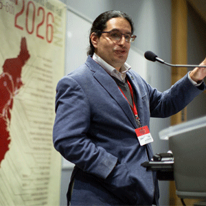 Eden Figueroa giving a speech in front of a board that reads "2026"