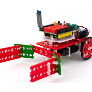 A small red and green wheeled robot with a circuit board and antenna, featuring extended arms, resembling a playful, modern toy.