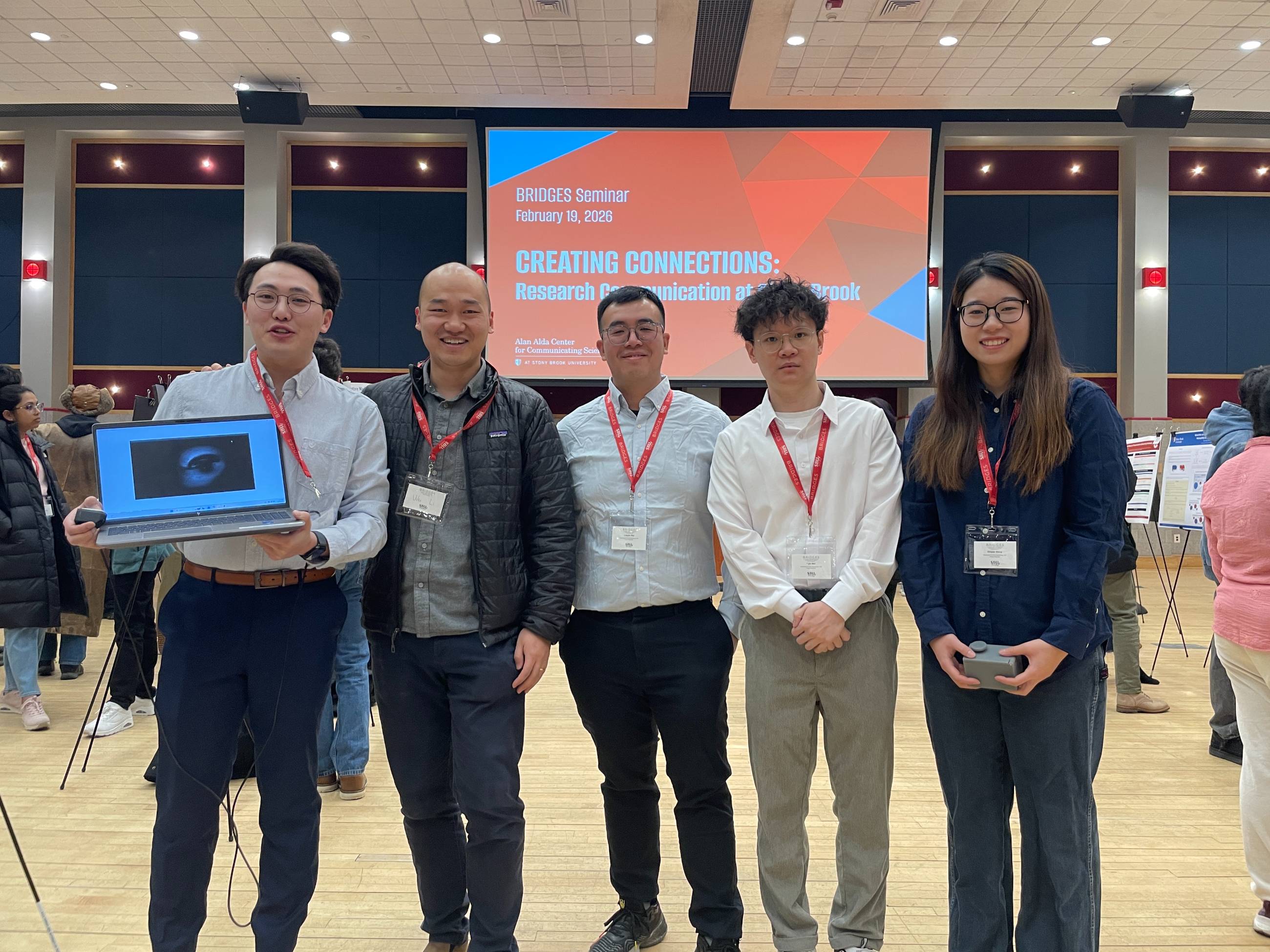 Graduate students at the Stony Brook University BRIDGES Seminar on Research Communication posing in front of a presentation screen.