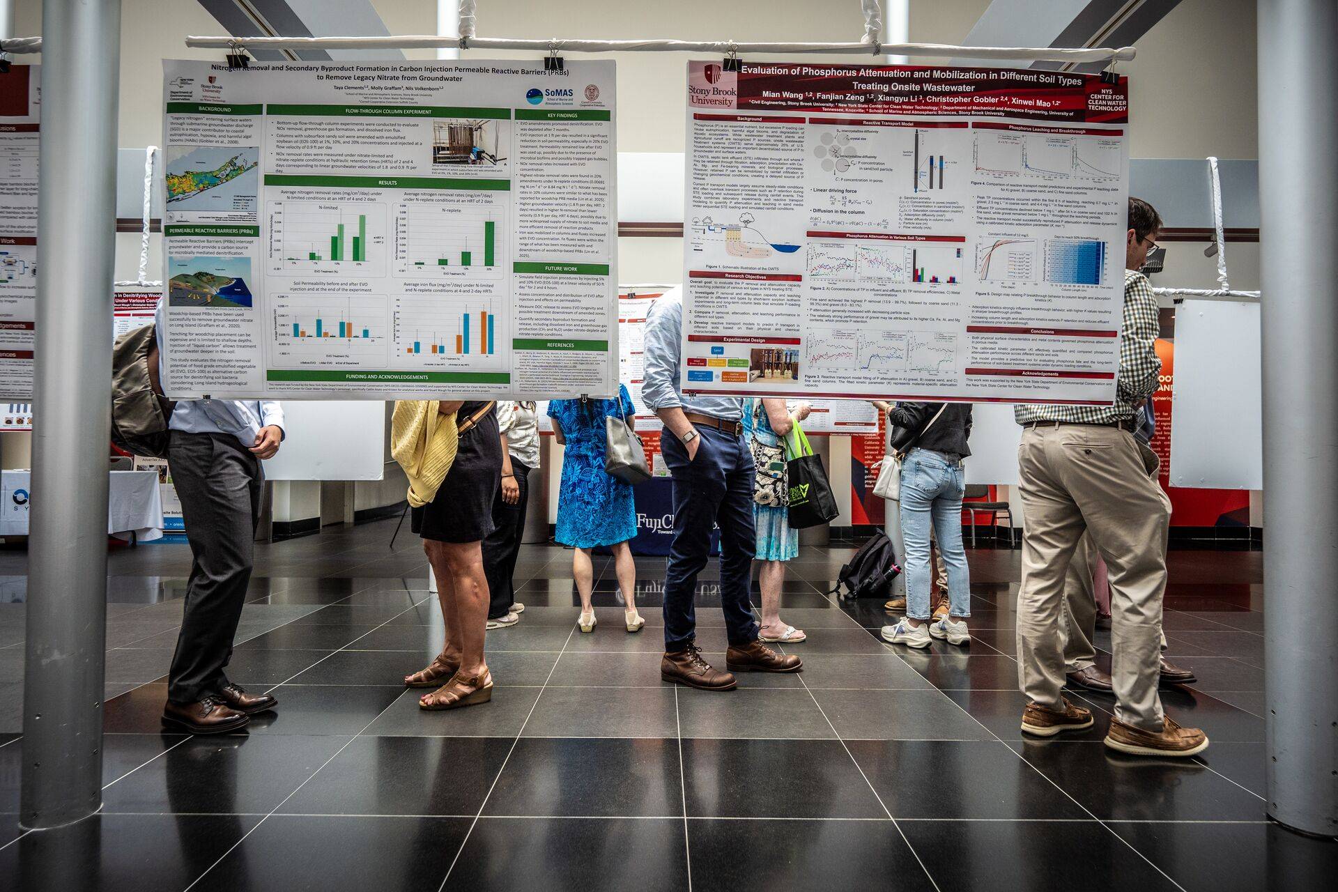 Attendees viewing academic research posters hanging at Clean Water Symposium