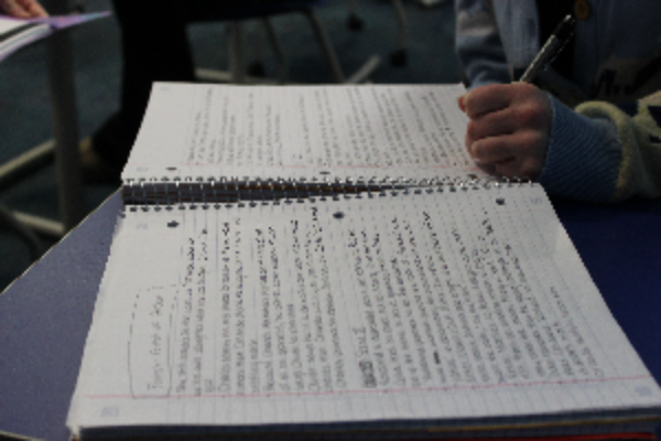 Student writing notes in their notebook