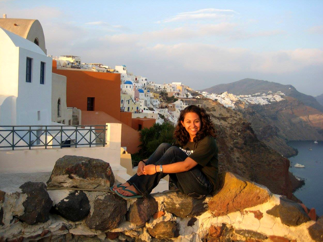 Student sitting on the rocks in a coastal Greek city