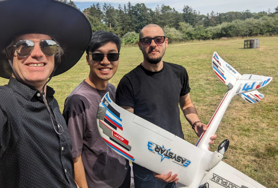 Researchers hold a UAV in a field