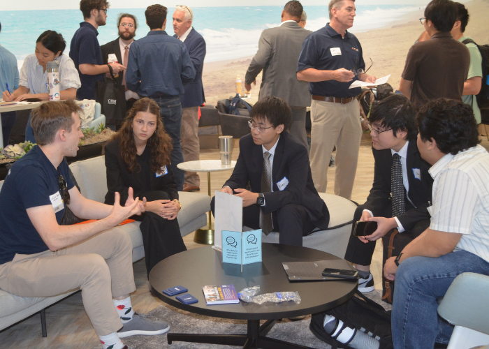 Students and Industry Partners chat around a table at the Friends of MEC Social.