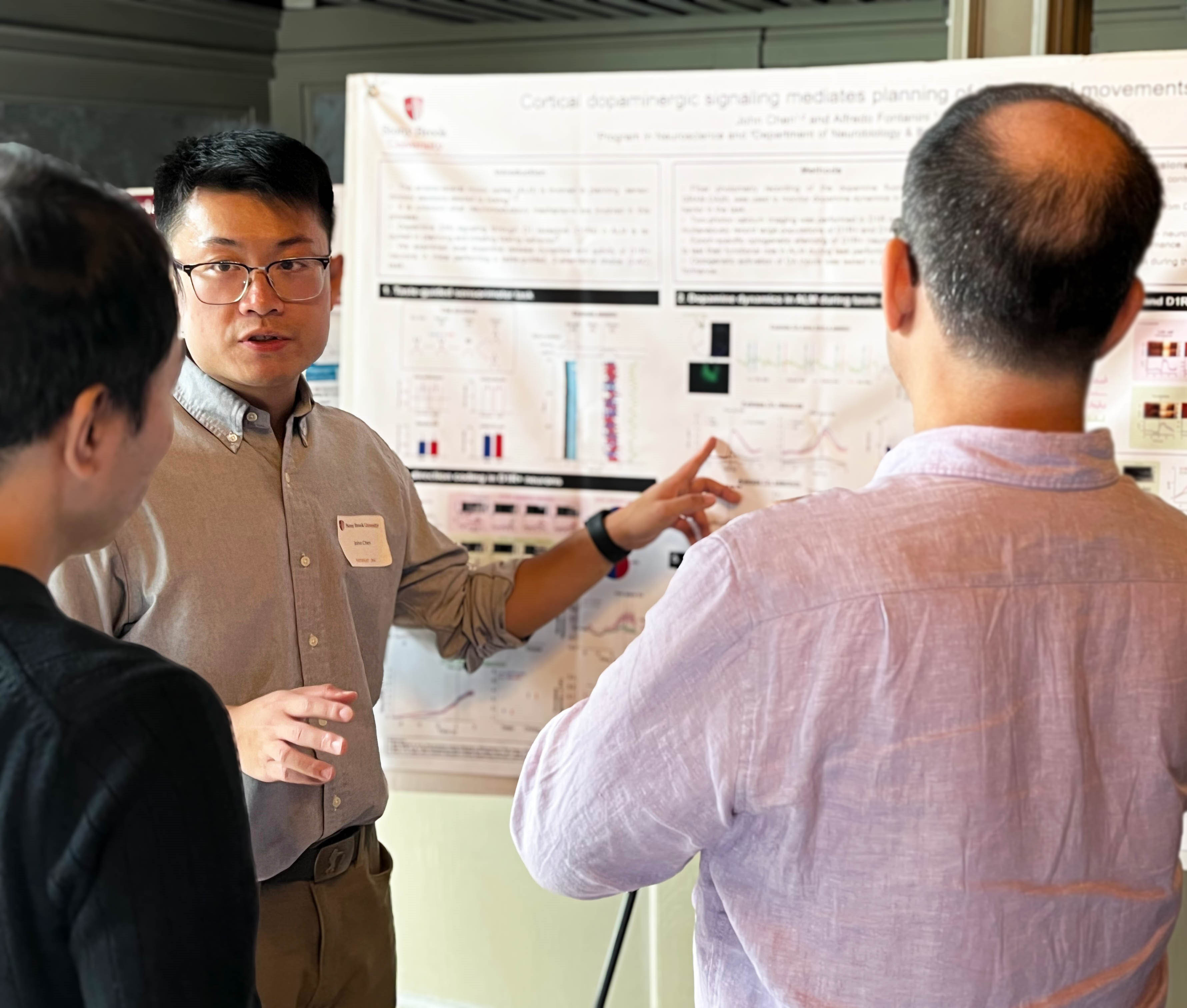 People at poster while student explains data