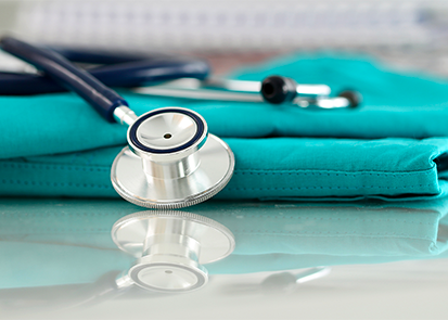 A stethoscope lying on top of a pair of scrubs