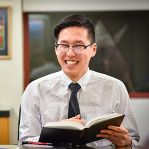  Smiling student in seminar setting with a book