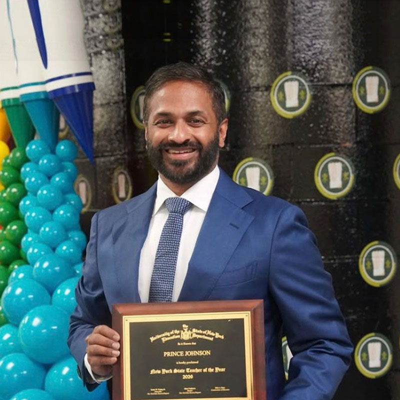 image of Prince Johnson holding the teacher of the year award