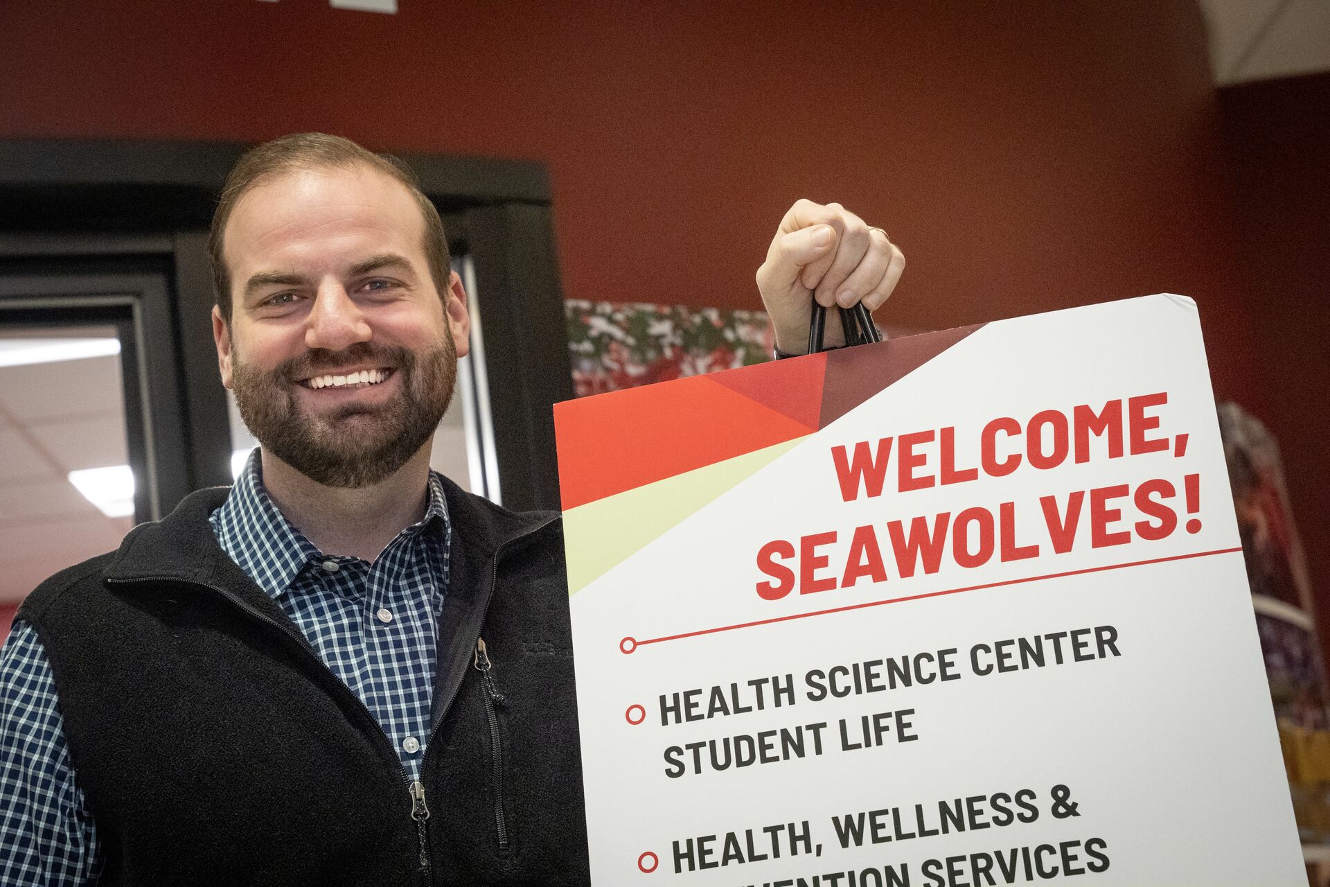 Caucasian man with facial hair holding sign