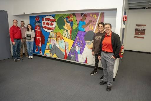 CBC Members and first ART Tank Winner standing in front of SBU students and Wolfie shown as super heros