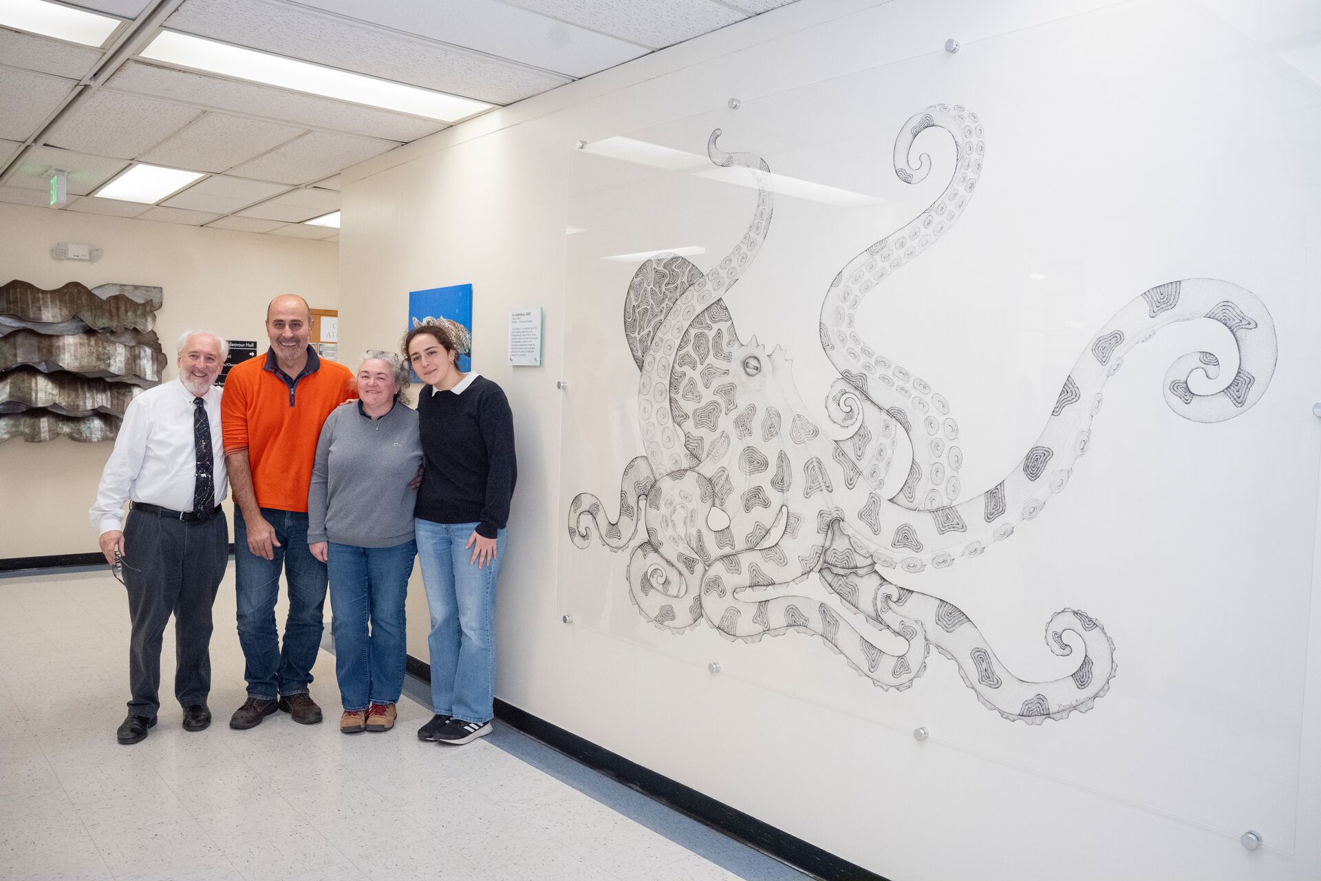 Staff standing by the Octopus mural 