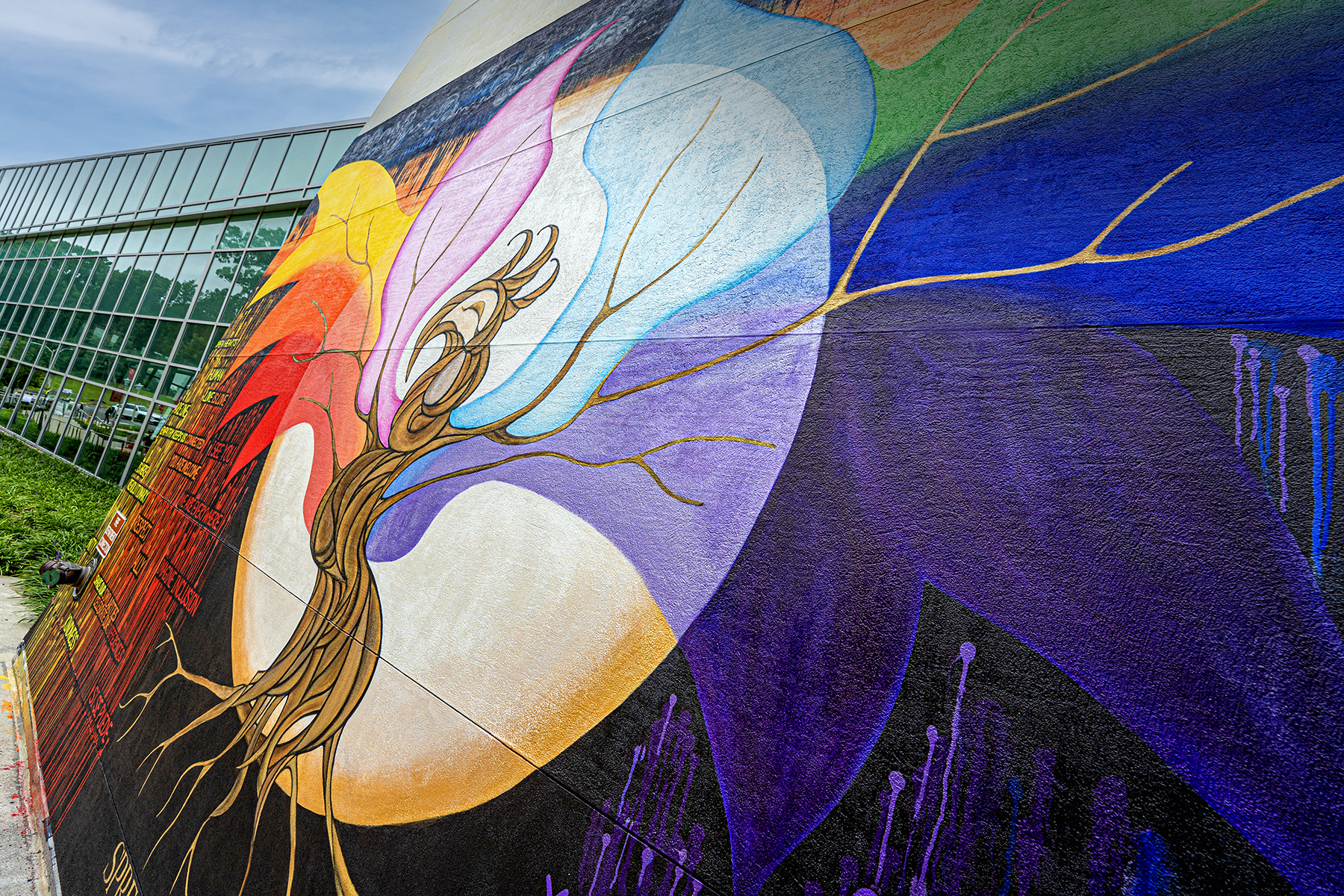 mural on the side of a building with a rainbow colored phoenix