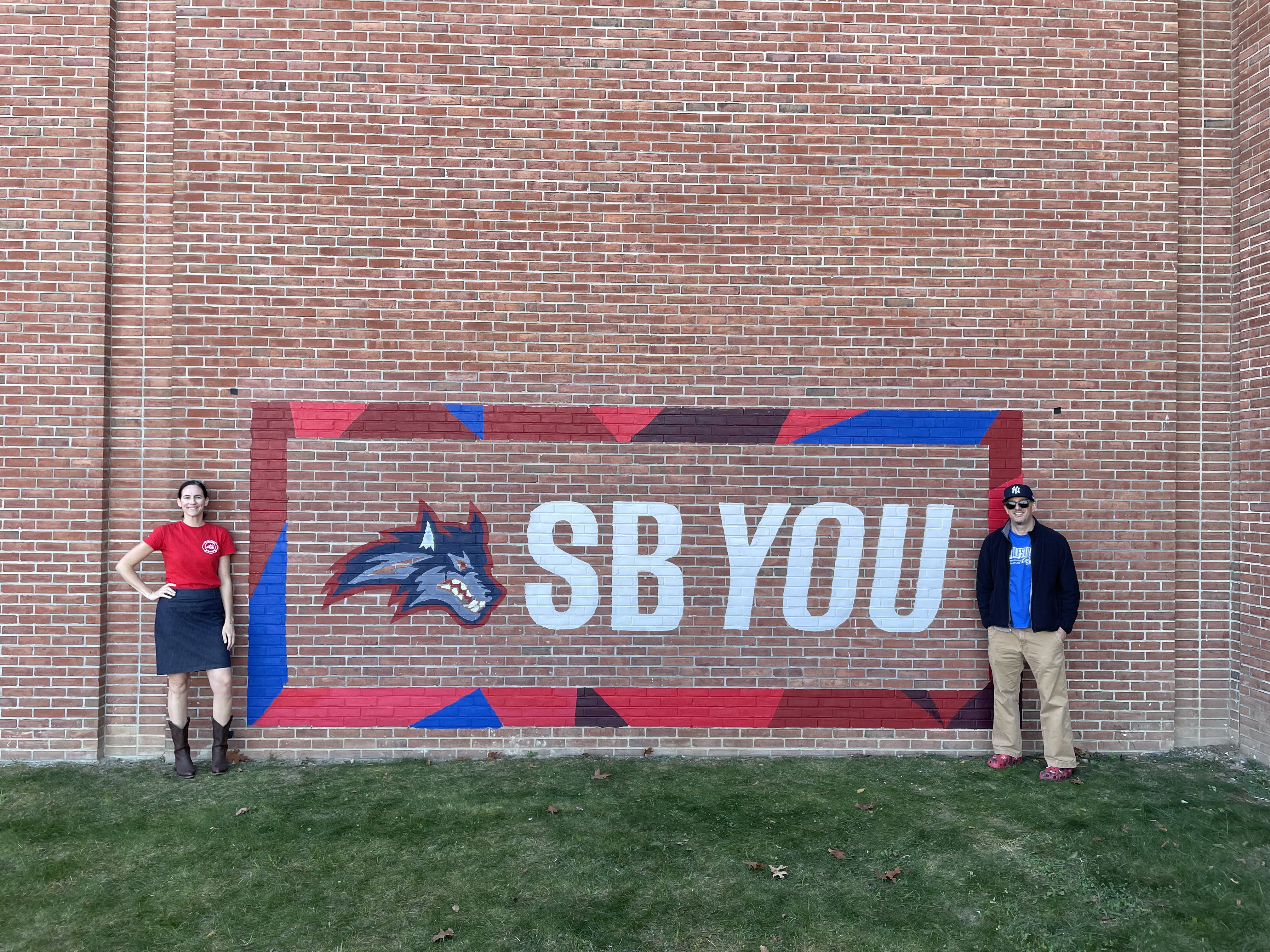 CBC members standing in front of SBYou mural on a brick wall