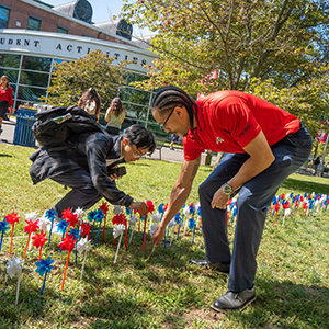A student and staff member place pinwheels at a 9/11 event.