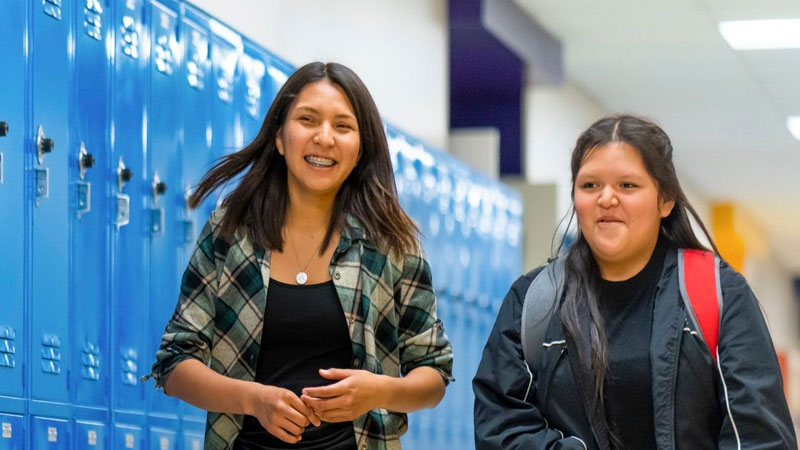 High school girls walking in front of lockers