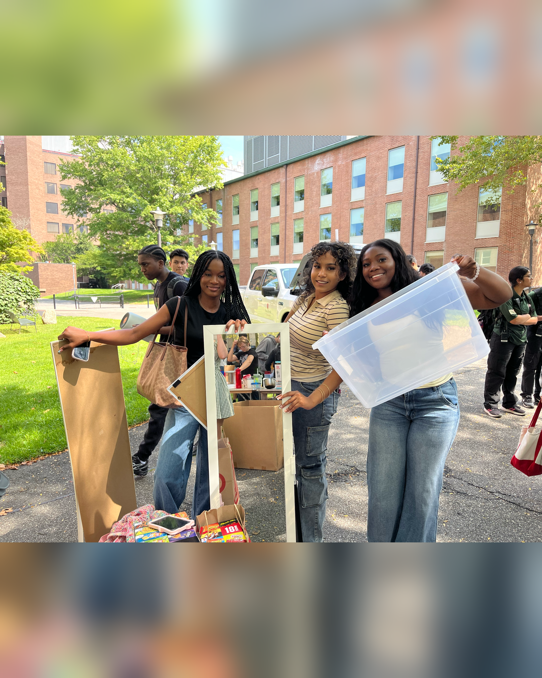 students holding recycled dorm room items