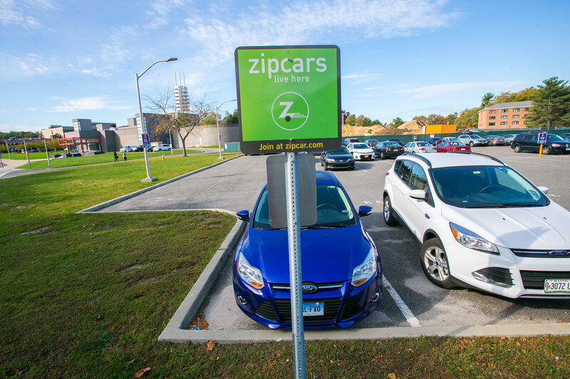 Cars parked beside a Zipcar sign on campus