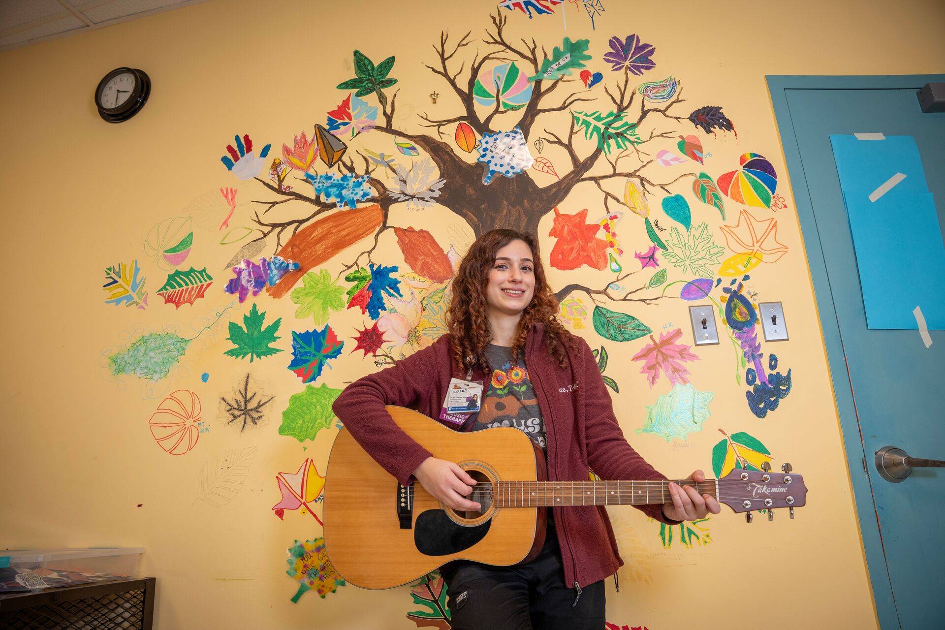 University staff member holding a guitar