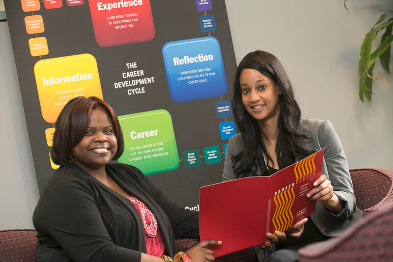 A student and adviser reviewing a Career Center folder