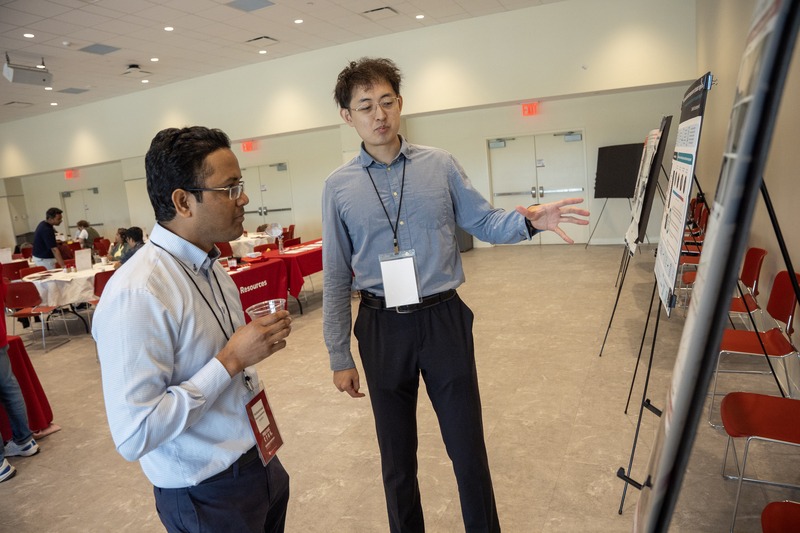 Two researchers discussing a poster presentation