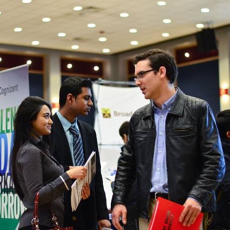 Students dressed professionally, holding company brochures