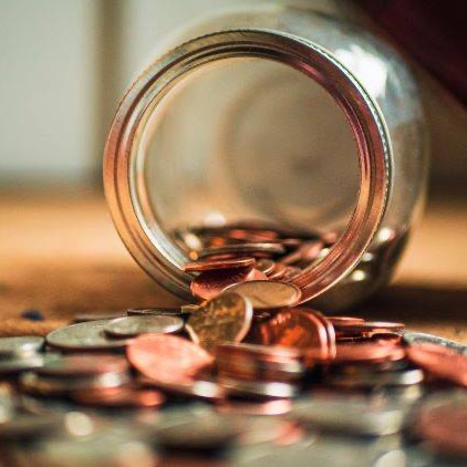 Glass jar spilling coins onto a counter