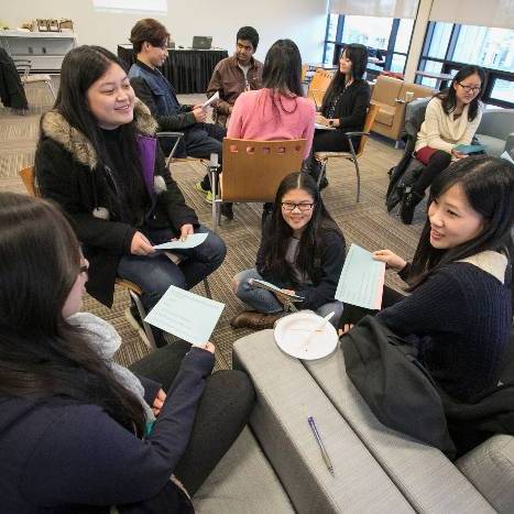 Students sitting in a group talking at an event