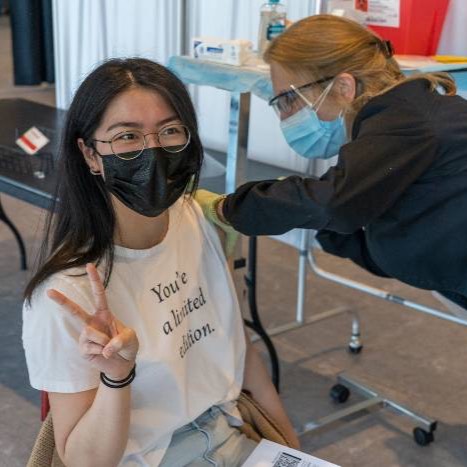 Student receiving a vaccination from a nurse