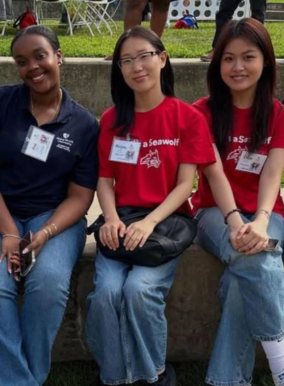 Three girls sitting on Staller steps wearing Stony Brook t-shirts