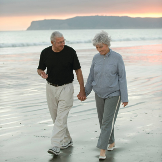 Couple walking along a beach representing relocation and quality of life near Stony Brook