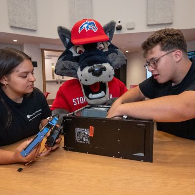 Students working together on a hardware project with computer hardware equipment at a table