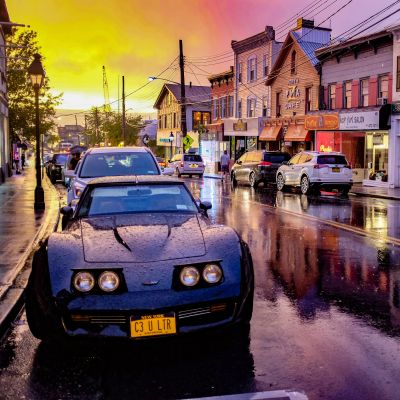 Port Jefferson village street at sunset with storefronts and cars
