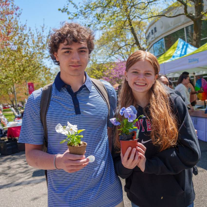  Two stduents holding flowers at Stony Brook University’s annual Earth Day celebration called Earthstock.