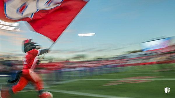 Mascot running with flag