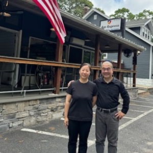 AM Express owners outside storefront