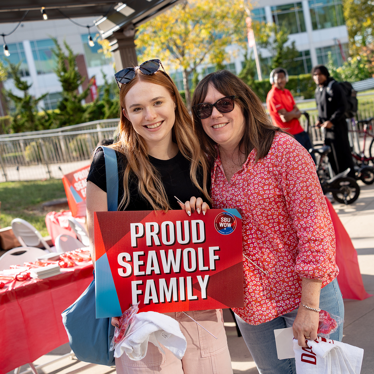 A mother and daughter with a sign reading, "Proud Seawolf Family."