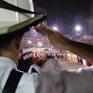 A september 11th first responder salutes with a crowd in the background