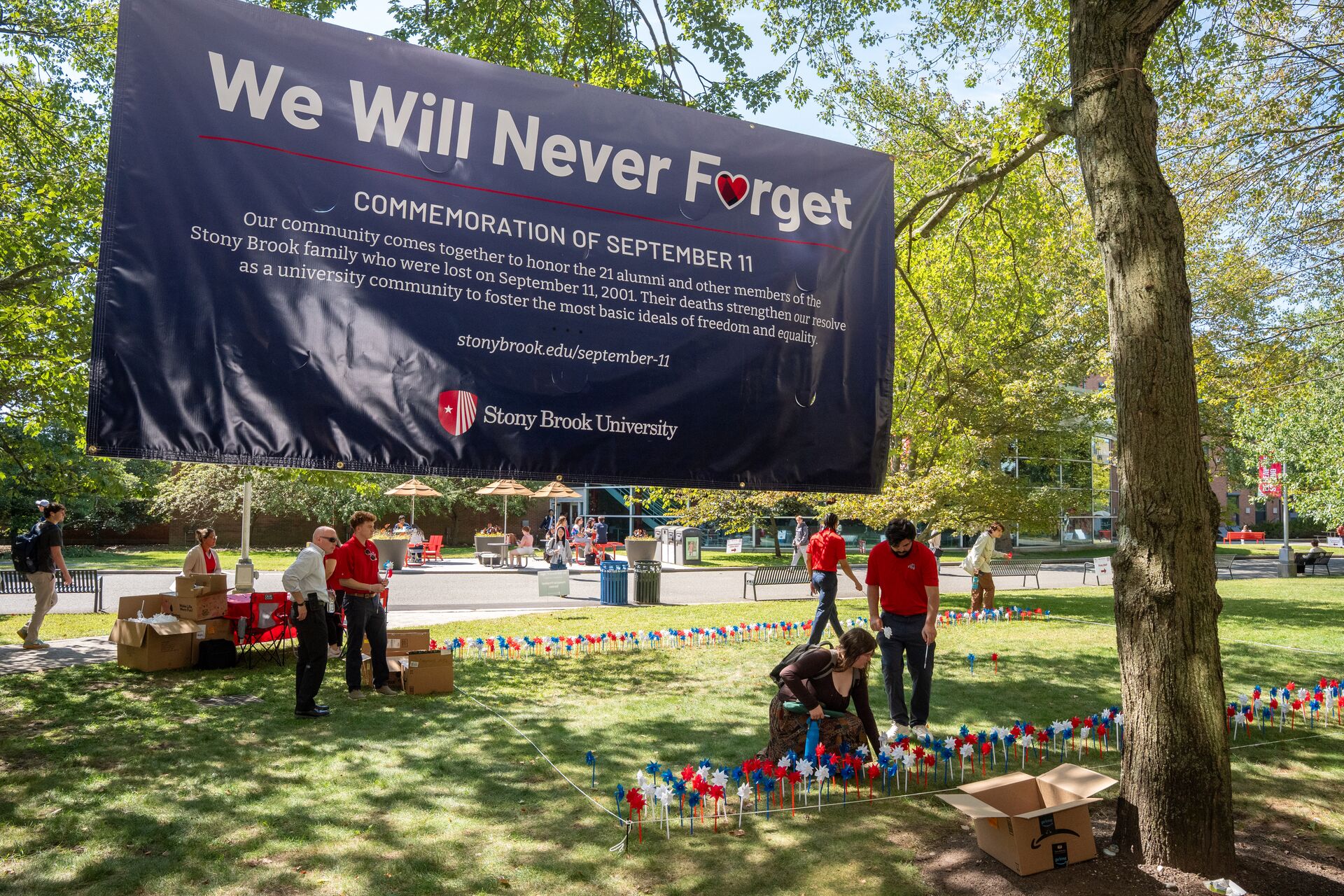 Photo showing students and staff at SBU placing memorial pinwheels on the academic mall in remembrance of Setpember 11, 2001.