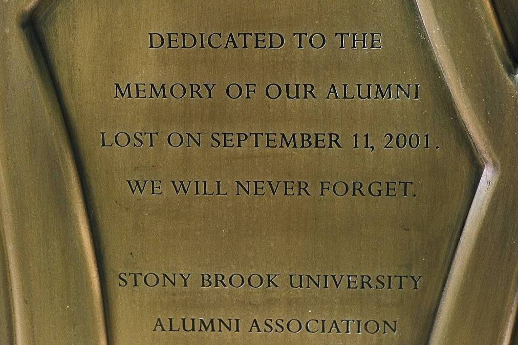Words on a September 11th memorial that read: Dedicated to the memory of our alumni lost on September 11, 2001. We will never forget. Stony Brook University Alumni Association.