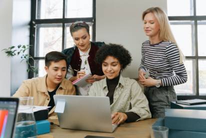 Students collaborating around a laptop